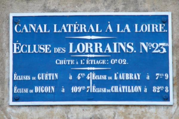 Il est écrit sur ce panneau : Canal latéral à la Loire - écluse des Lorrains. N°23 - Chute à l'étiage : 0,02m - écluses de 
Guétin à 4,400 km, écluse de l'Aubray à 7,900 km - écluse de Digoin à 109,700 km, écluse de Châtillon à 82,800 km