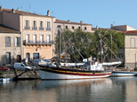 Sur les quais de l'Hérault à Agde, un beau voilier décoré de noir, or, rouge et blanc