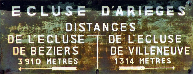 Panneau indicateur de l'écluse d'Arieges. Distance jusqu'à l'écluse dde Béziers : 3910 mètres, 
et jusqu'à l'écluse de Villeneuve : 1314 mètres
