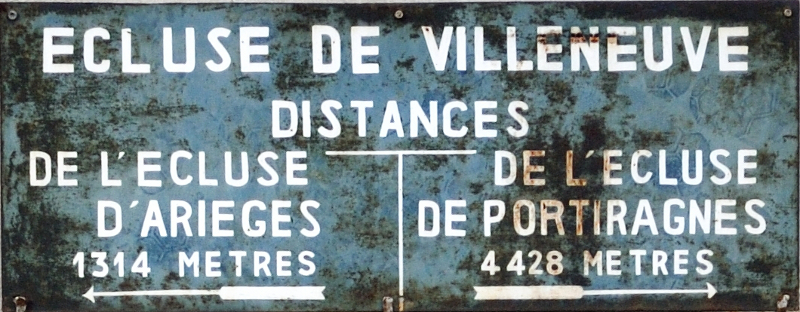 Panneau indicateur de l'écluse de Villeneuve. Distance jusqu'à l'écluse d'Arièges : 1314 mètres, et jusqu'à l'écluse de Portiragnes : 4428 mètres