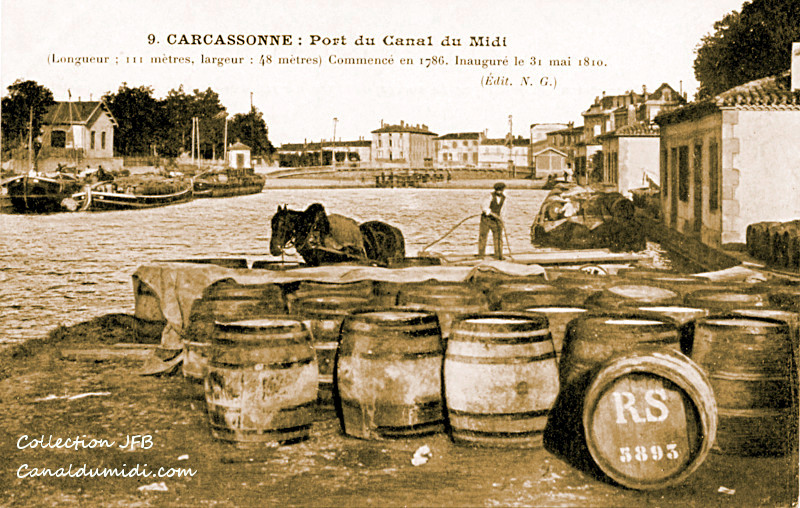 Le port de Carcassonne. Sur les quais, de nombreuses barriques de vin. Un homme s'active à manipuler cette marchandise en utilisant un cheval de halage
