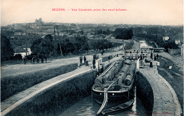 Les &eacute;cluses de Fons&eacute;rannes au premier plan une p&eacute;niche charg&eacute;e de barriques de vin qui descend vers B&eacute;ziers; Un attelage et au fond, la ville de B&eacute;ziers