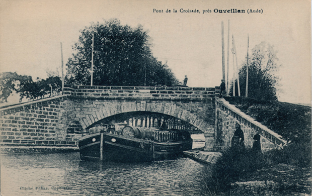 Une péniche chargée de barriques de vin, passe sous un pont, près d'Ouveillan, dans l'Aude