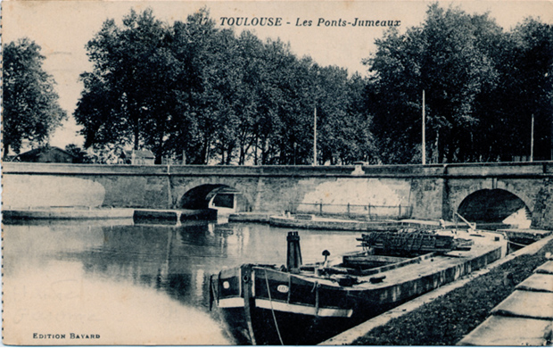 Une péniche, chargée de ferraille, est amarrée aux ponts jumeaux, près de l'embouchure sur la Garonne