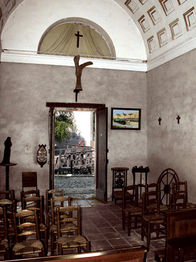 Une autre vue de l'intérieur de la chapelle. La porte est grande ouverte et à l'extérieur, on aperçoit l'écluse.